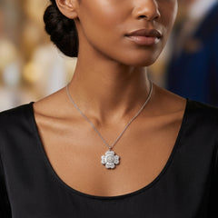 A close-up of a woman wearing a silver-toned flower-shaped pendant necklace with clear stones, paired with a black scoop-neck top.